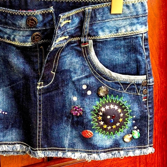 Bebe embellished denim skirt with buttons and colorful decorative details. - Picture 2 of 6